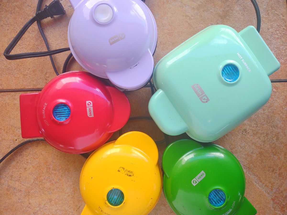 Different types of Dash MIni Waffle makears that are purple, light blue, red, yellow, and green.