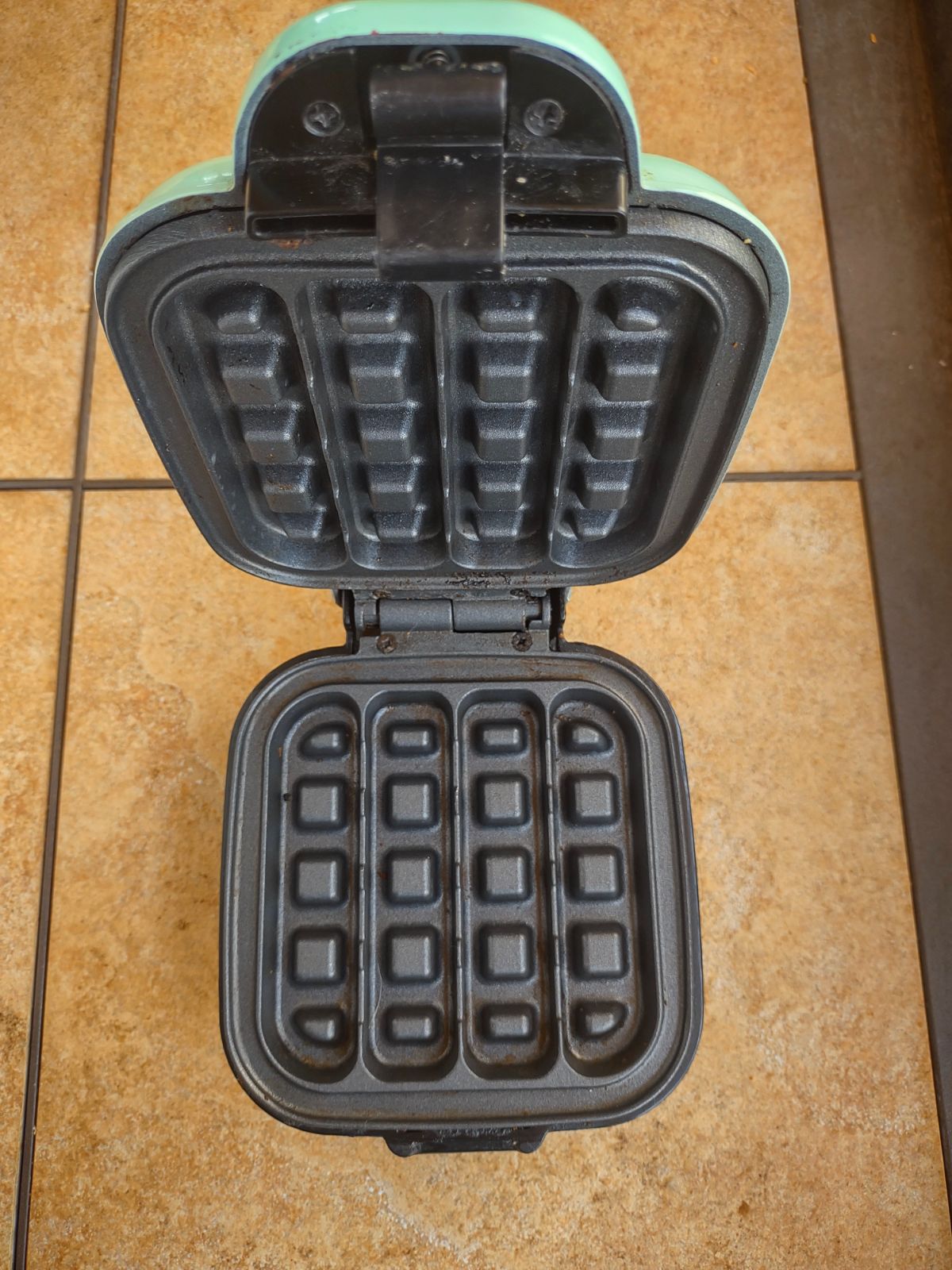 An opened Dash waffle stick maker showing the inside.