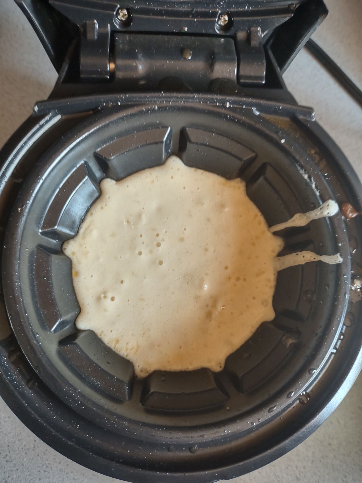 Batter inside a Presto waffle maker, up to the fill line.