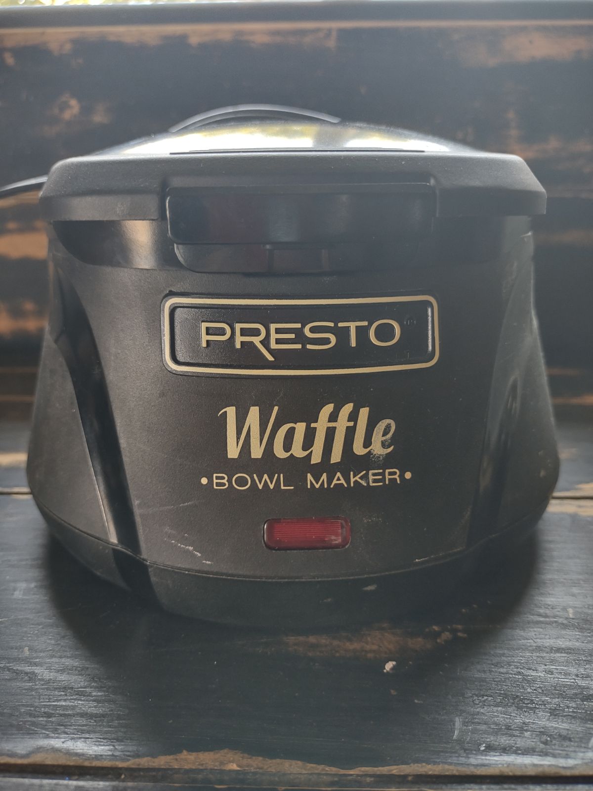 Black Presto Waffle Bowl Maker sitting near a window.